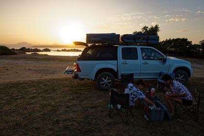 Isuzu mit zwei Dachzelten vor Sonnenuntergang am Meer