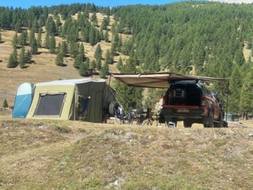 Anhängerzelt aufgebaut neben Auto mit Markise