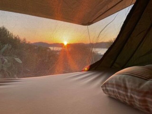 Blick aus dem Dachzeltfenster auf den Sonnenuntergang