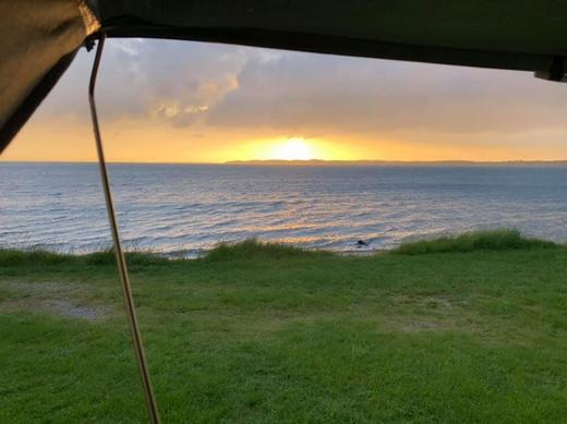 Blick aus dem Dachzelt auf Sonnenuntergang am Meer