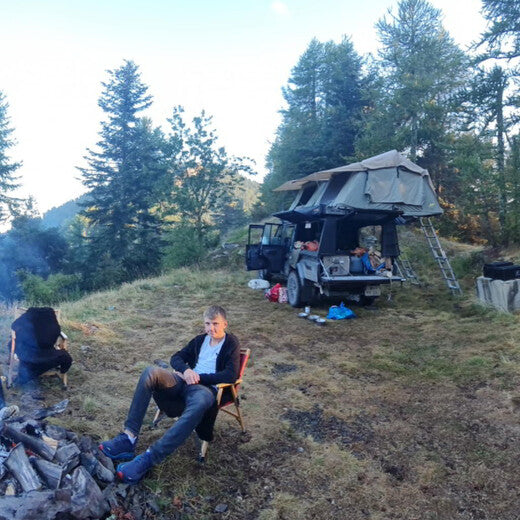 Zwei Faltdachzelte auf Landcruiser mit Mann am Lagerfeuer