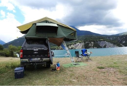Ford Ranger mit Dachzelt am See mit Campingstühlen davor