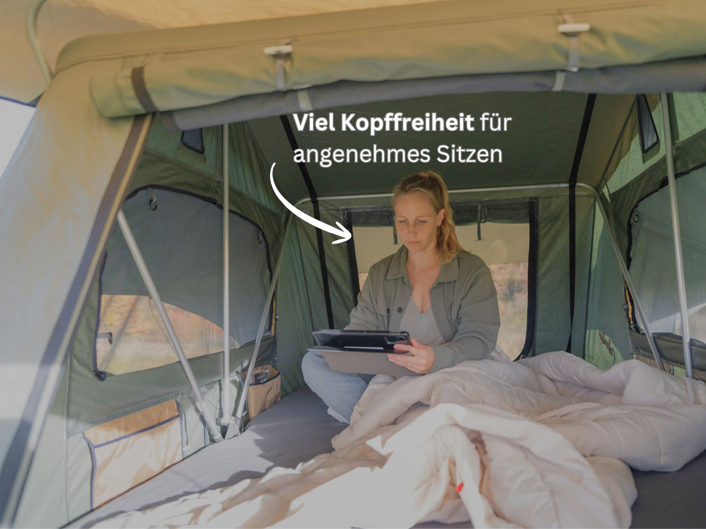 Frau sitzt mit Tablet in der Hand im Dachzelt Tanami Light 